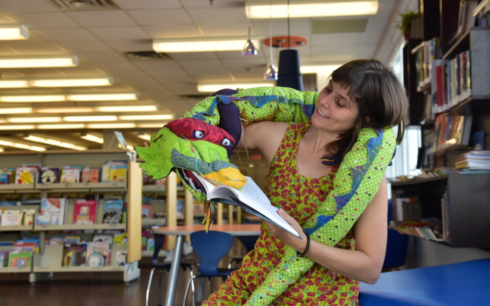 Fille regarde son serpent en peluche vert